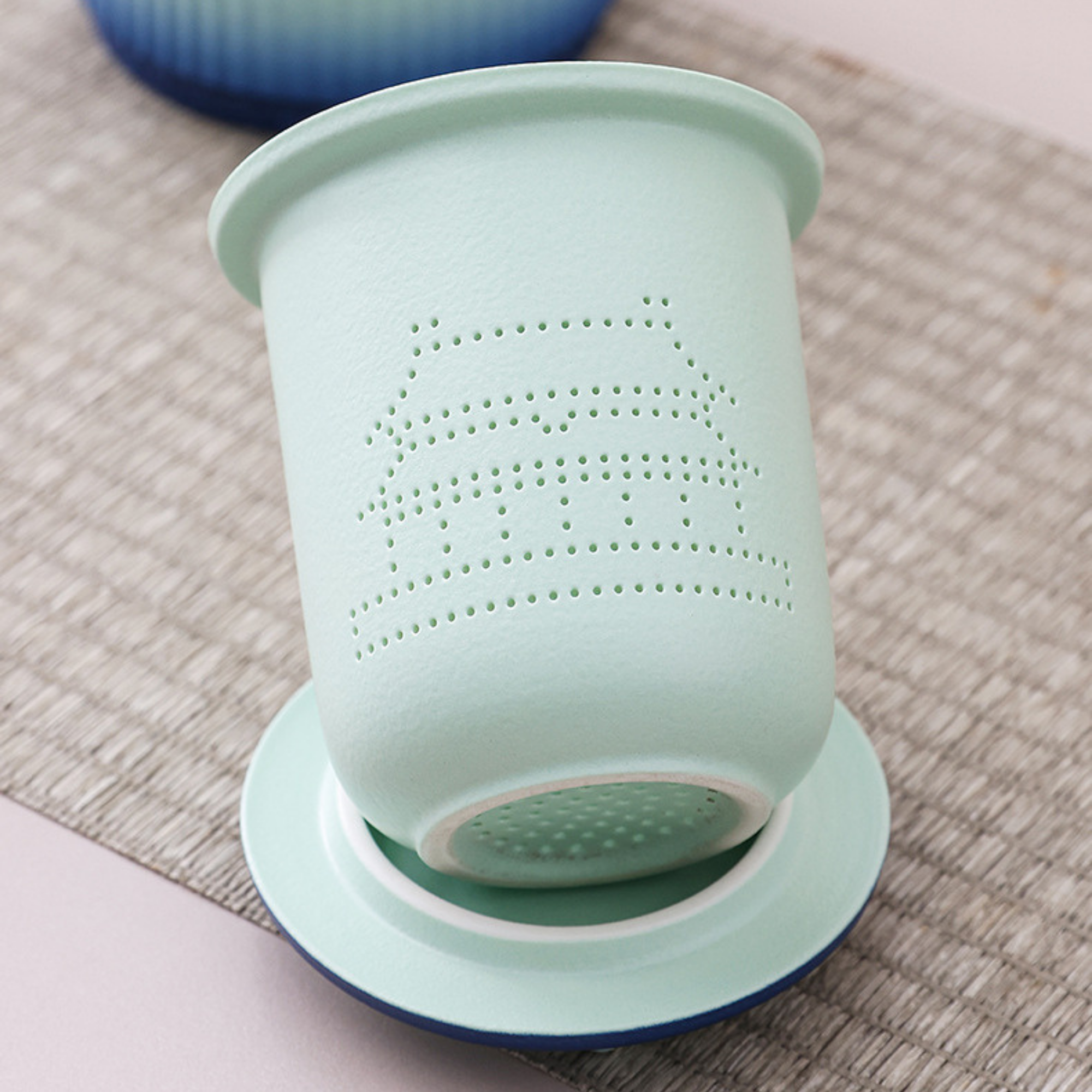 Green silicone cup with perforated design on a textured surface