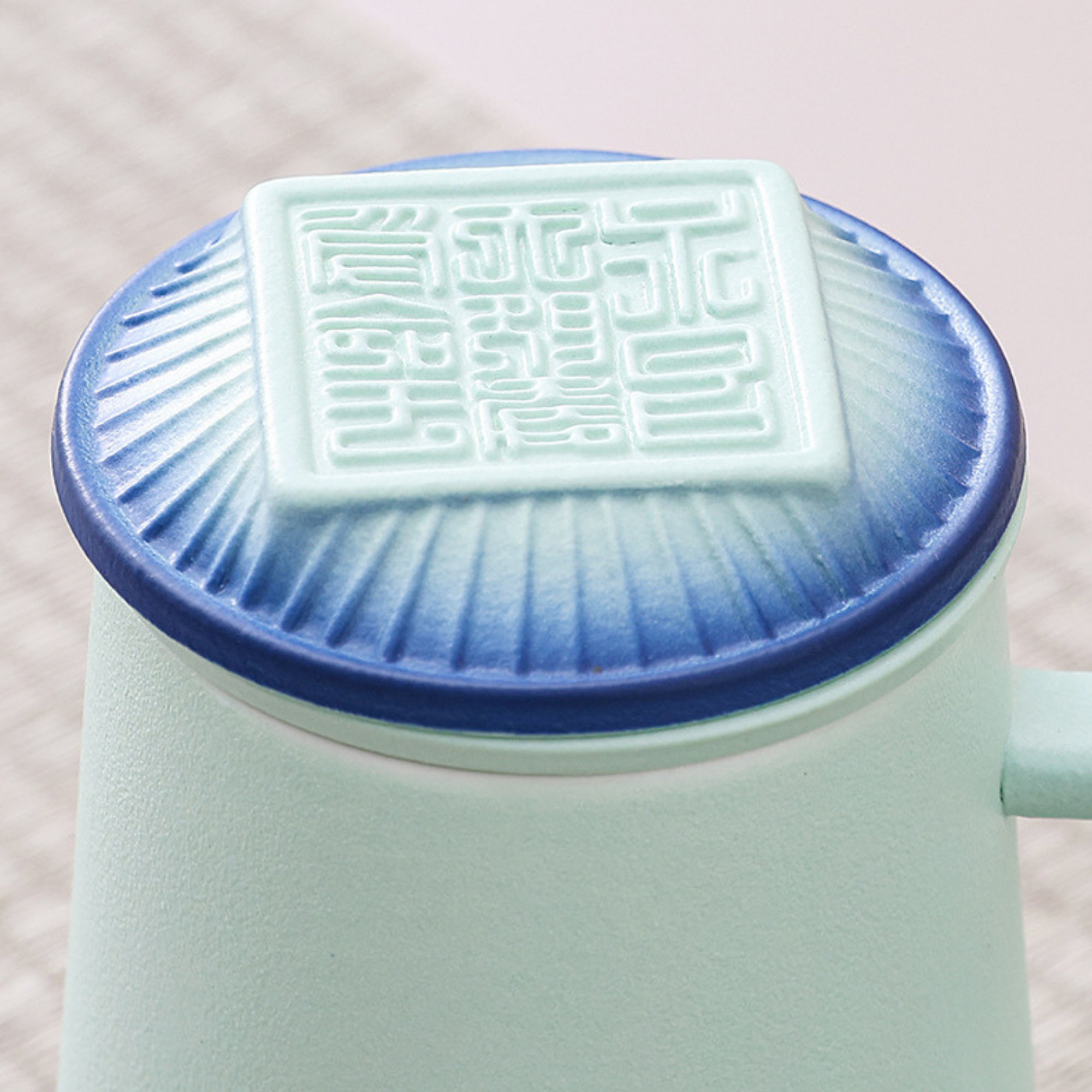 Light blue mug with a decorative lid featuring intricate patterns on a light background