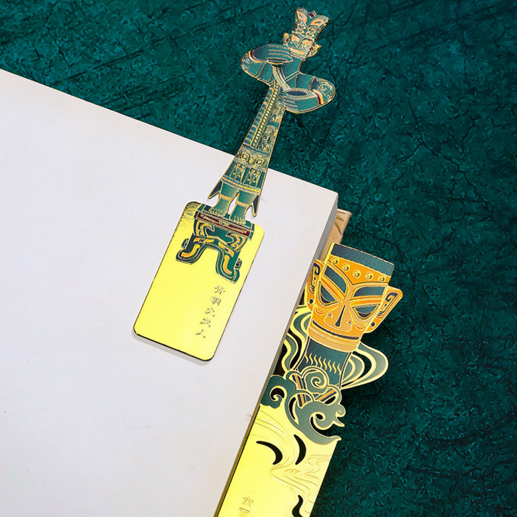 Decorative bookmarks with intricate designs on a textured green surface