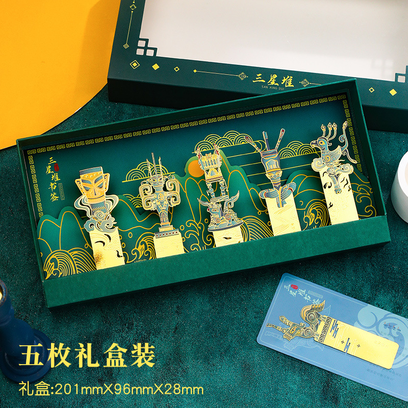 Decorative box with artistic designs and text on a green surface