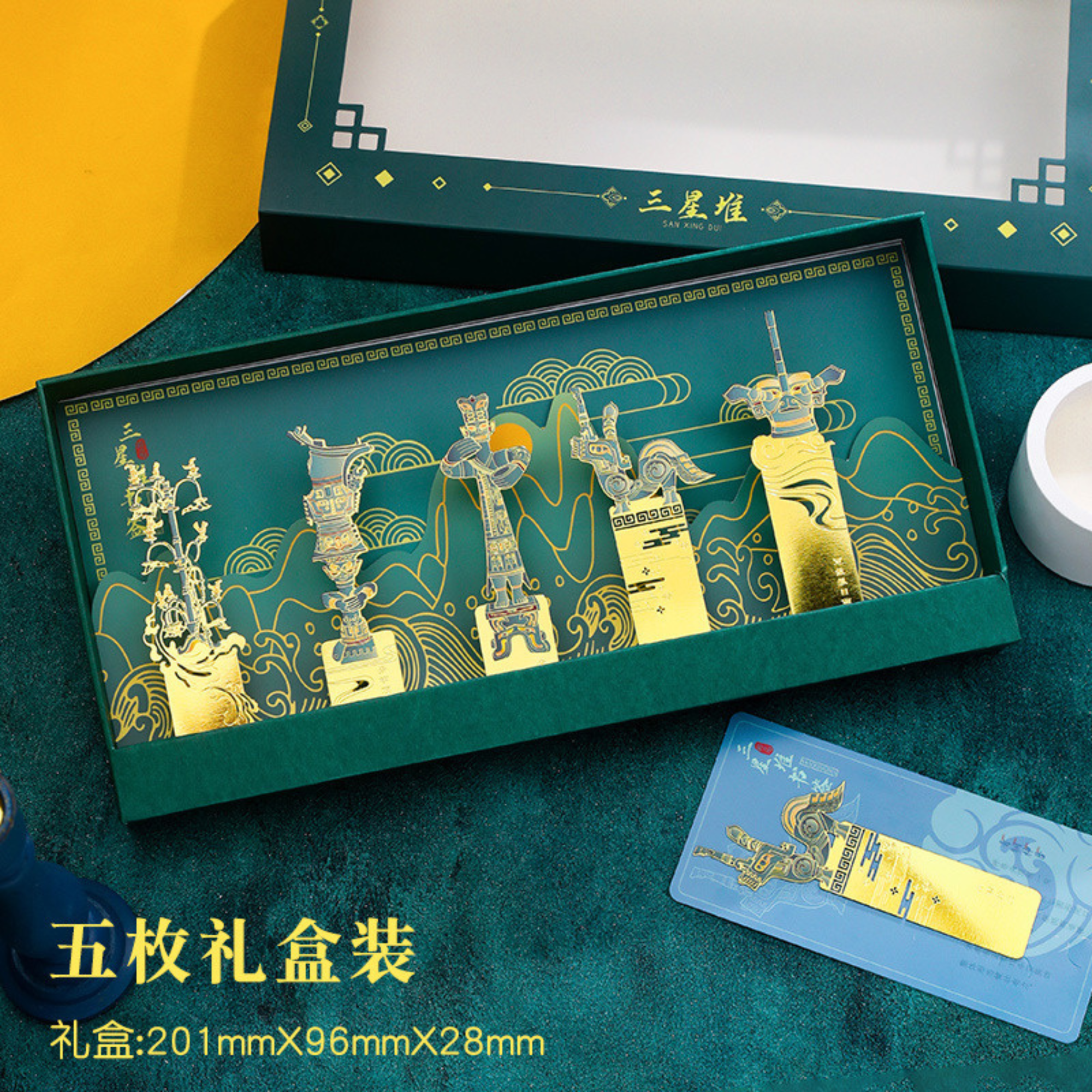 Decorative box with gold illustrations on a green background