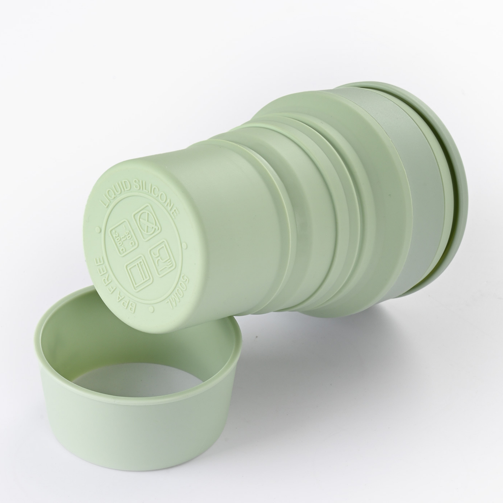 Collapsible green silicone cup on a white background