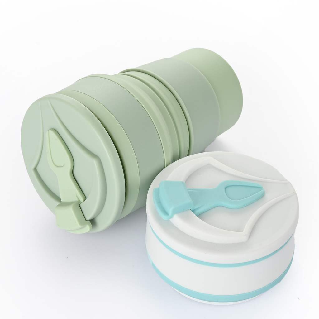 Two collapsible silicone cups, one green and one white with blue accents, on a white background.