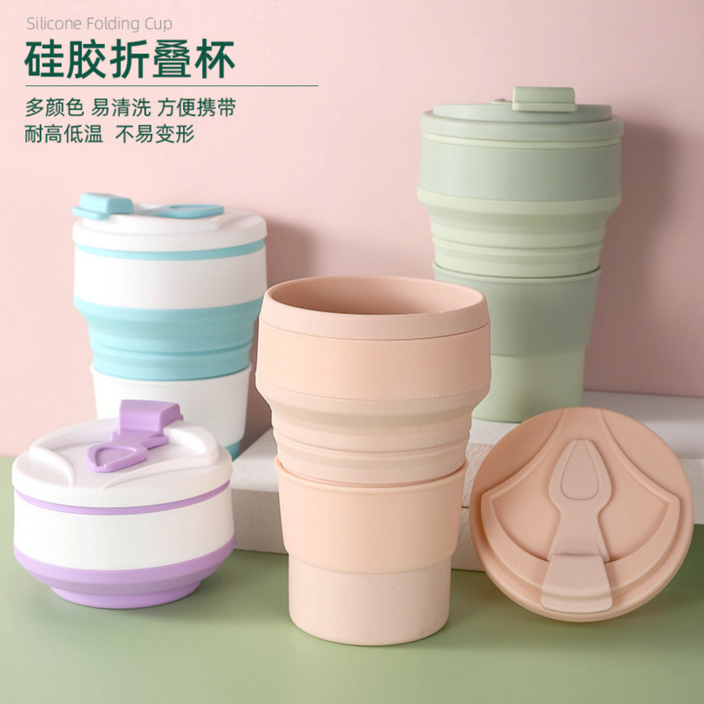 Set of silicone folding cups in pastel colors with lids on a pink background